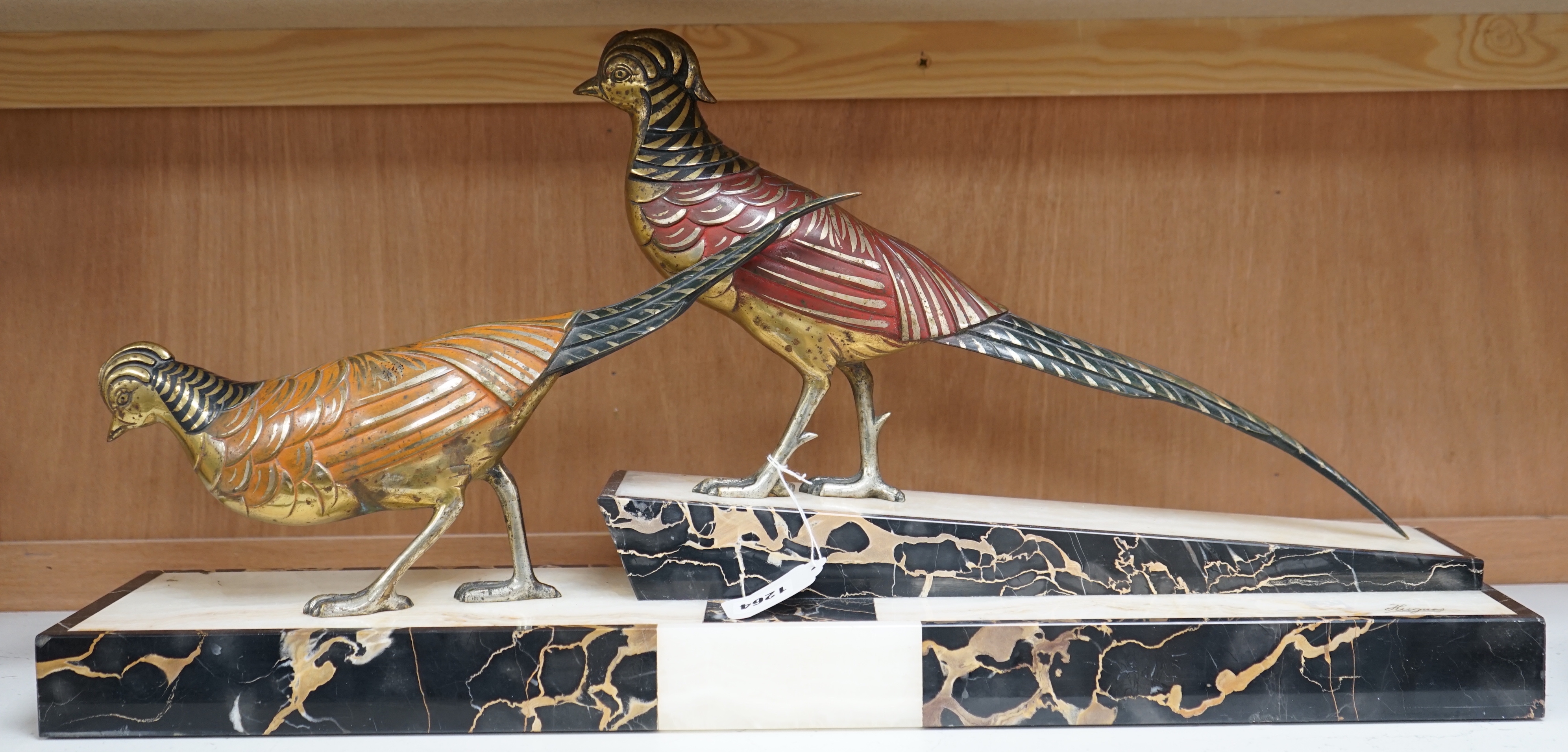 An Art Deco patinated bronze model of two pheasants on marble base, stamped ‘bronze’ and signed ‘Hugues’, 70cm long
